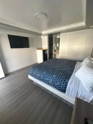 a bedroom with a bed and a flat screen tv at HomeTown Inn in Los Banos
