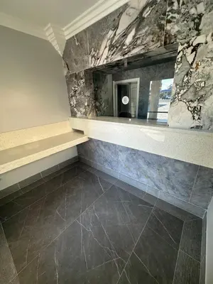 a bathroom with a counter and a stone wall at HomeTown Inn in Los Banos