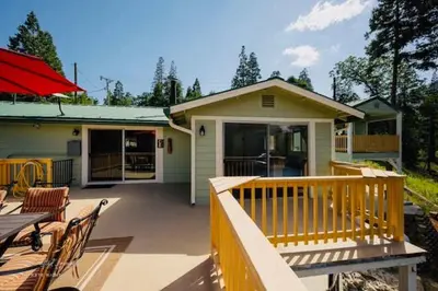 a porch of a house with a table and chairs at Lake View Suite for 2-Hot Tub-Dog Friendly in Bass Lake Annex