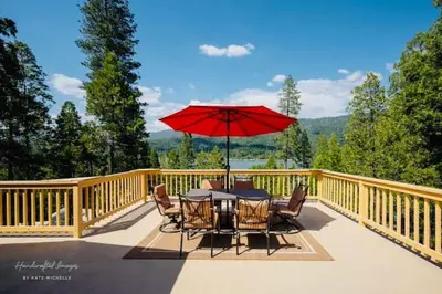 a table and chairs with a red umbrella on a deck at Lake View Suite for 2-Hot Tub-Dog Friendly in Bass Lake Annex