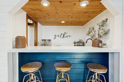 a kitchen with two stools and a counter with blue paint at Hot Tub, Game Room and Home Gym Serene Arnold Gem in Arnold