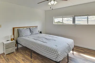 a white bedroom with a bed and a window at Mtn-View Coulter Escape with Rustic Tree Lookout in Coulterville