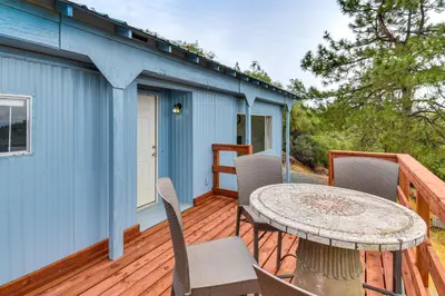 a patio with a table and chairs on a deck at Mtn-View Coulter Escape with Rustic Tree Lookout in Coulterville