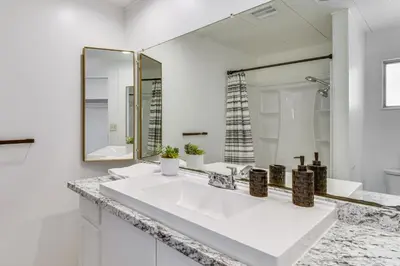 a white bathroom with a sink and a mirror at Mtn-View Coulter Escape with Rustic Tree Lookout in Coulterville