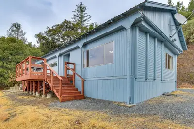 a blue tiny house with a wooden staircase at Mtn-View Coulter Escape with Rustic Tree Lookout in Coulterville