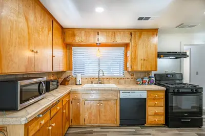 a kitchen with wooden cabinets and a sink and a stove at Cozy Cabin by Bass Lake, with Boat Slip in Bass Lake