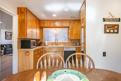 a kitchen with a table and chairs and a kitchen with a sink at Cozy Cabin by Bass Lake, with Boat Slip in Bass Lake