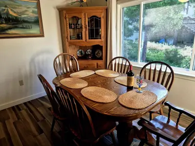a dining room table with chairs and a large window at Cozy Cabin by Bass Lake, with Boat Slip in Bass Lake