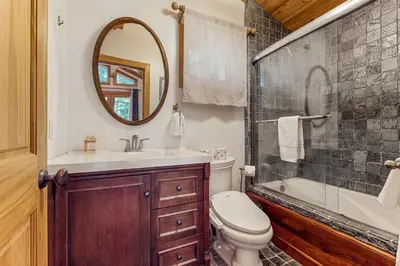 a bathroom with a toilet and a sink and a mirror at Tahoe Timber Retreat in Carnelian Bay