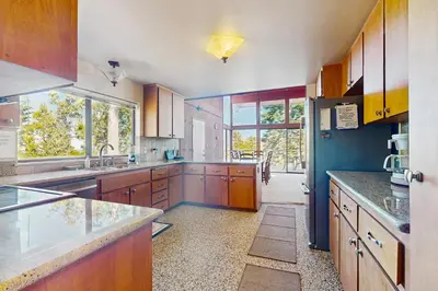 a large kitchen with wooden cabinets and a large window at Dogwood Hollow in Shaver Lake
