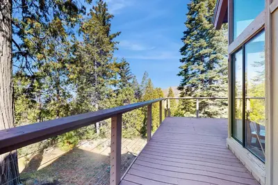 a wooden deck with a view of the woods at Dogwood Hollow in Shaver Lake