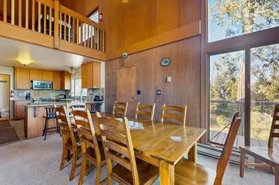 a kitchen and dining room with a wooden table and chairs at Dogwood Hollow in Shaver Lake