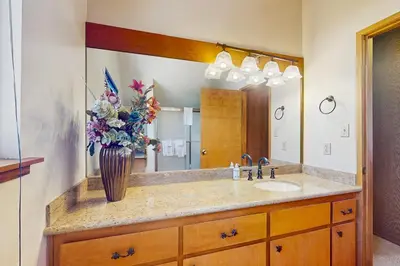a bathroom with a sink and a vase of flowers at Dogwood Hollow in Shaver Lake