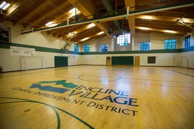 a gym with a basketball court with an insurance village improvement district sign on the floor at Sierra Snow Haven in Incline Village