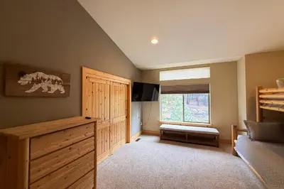 a bedroom with a bed and a dresser and a window at Tahoe Boulders in South Lake Tahoe
