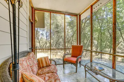 a screened in porch with a couch and a glass table at All-Season Outdoor Base Camp Gold Country Home! in Fiddletown