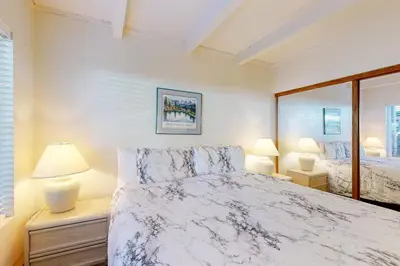 a white bedroom with a bed and two lamps at Val D'Isere 30 in Mammoth Lakes
