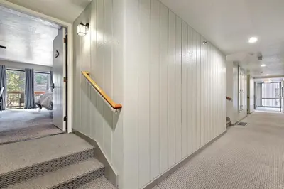 a hallway with white walls and stairs in a house at Yosemite West Condo B104 in Yosemite West