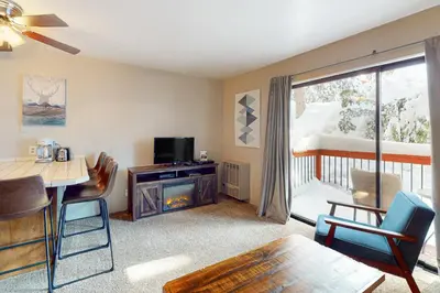 a living room with a television and a table and chairs at Yosemite West Condo B104 in Yosemite West