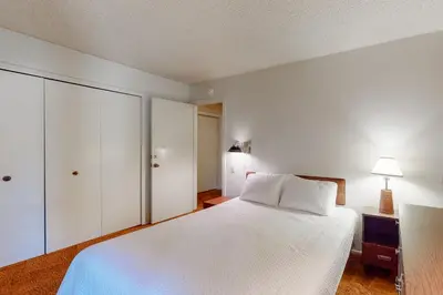 a large white bedroom with a bed and a dresser at Fireside 111 in Mammoth Lakes