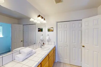 a bathroom with a sink and a large mirror at Moler Lake House in Bass Lake