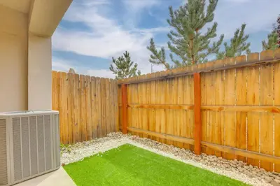 a backyard with a wooden fence and green grass at Home Base with Easy 1-80 Access 4 Mi to Dtwn Reno! in Reno