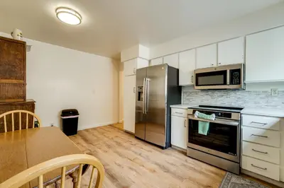 a kitchen with stainless steel appliances and a table at 2 Mi to Dtwn Reno and UNR City-View Townhome! in Reno