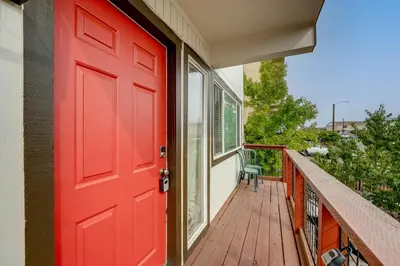a red door on a house with a balcony at 2 Mi to Dtwn Reno and UNR City-View Townhome! in Reno