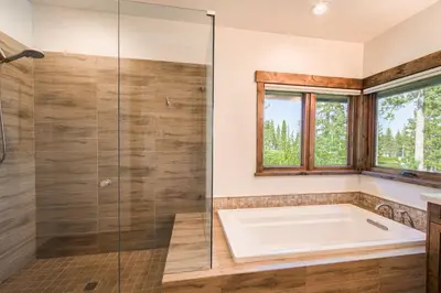 a bathroom with a tub and a glass shower at Rising Sun Retreat at Schaffer's Mill by Tahoe Getaways - Luxury Pet Friendly w Air Conditioning in Truckee