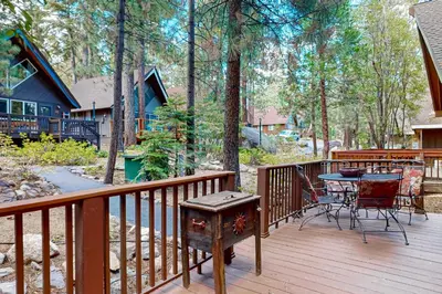 a deck with a table and chairs and a grill at Camp Tahoe in Incline Village