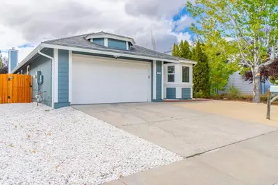 a house with a white garage with a driveway at Modern Western Retreat Pet Friendly 4 Bed 2 Bath in Reno