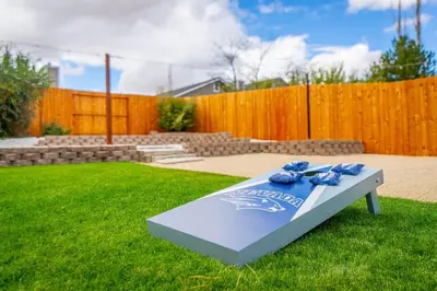 a bench in a yard with blue flowers on it at Modern Western Retreat Pet Friendly 4 Bed 2 Bath in Reno