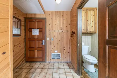 a bathroom with a toilet and wooden walls at Townhouse wLake View #254 at Donner Lake Village in Truckee