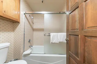 a bathroom with a toilet and a glass shower door at Townhouse wLake View #254 at Donner Lake Village in Truckee