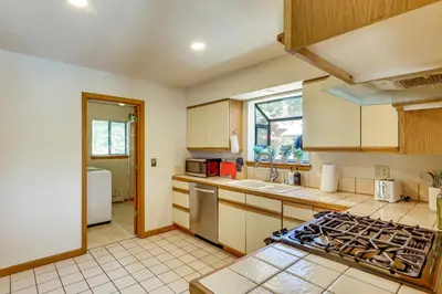 a kitchen with a stove top oven next to a sink at 3 Mi to Lake Tahoe Forest-View Sanctuary with Deck! in Incline Village
