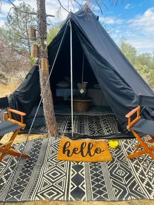a tent with a sign that says help on the floor at Rocky Ridge Glamping Yosemite in Coarsegold