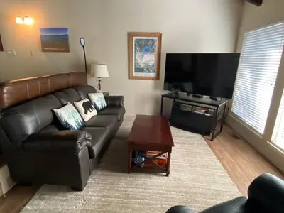 a living room with a leather couch and a flat screen tv at Lake Village Resort 3 bedroom condo in Zephyr Cove