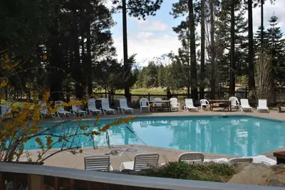 a large swimming pool with chairs and a table at Lake Village Resort 3 bedroom condo in Zephyr Cove