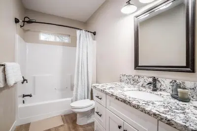 a bathroom with a sink and a toilet and a mirror at The Oakhurst Oasis - Family & Fun Edition in Oakhurst