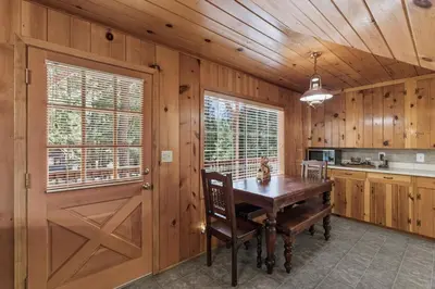 a kitchen with a table and a wooden wall at Dogwood Star Star Location Cozy Vibes in Shaver Lake