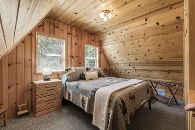 a bedroom with a bed in a wooden cabin at Dogwood Star Star Location Cozy Vibes in Shaver Lake