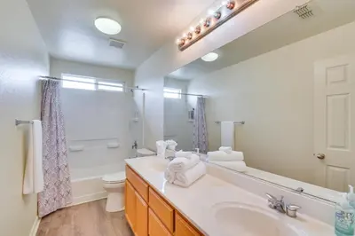 a bathroom with a sink and a toilet and a mirror at 7 Mi to Lake Yosemite Family Home with Fenced Yard in Merced