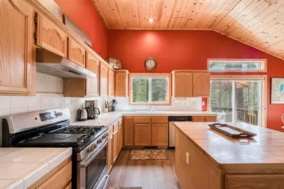 a kitchen with red walls and wooden cabinets at Scarlet Hollow Cabin at Tahoe Donner by Tahoe Getaways - 3BR w HOA Amenities in Truckee