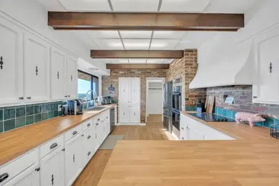 a kitchen with white cabinets and a brick wall at Ranch Stay-A 240 acre Working Ranch in Granite Bay