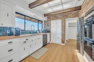 a kitchen with white cabinets and a brick wall at Ranch Stay-A 240 acre Working Ranch in Granite Bay