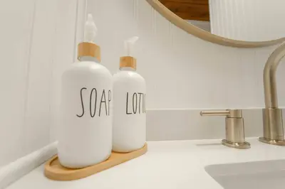two white bottles sitting on a bathroom counter next to a sink at Sequoia Vintage A-frame River Retreat in Three Rivers