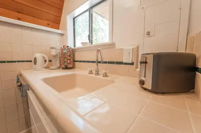 a kitchen with a large sink and a window at Sequoia Vintage A-frame River Retreat in Three Rivers