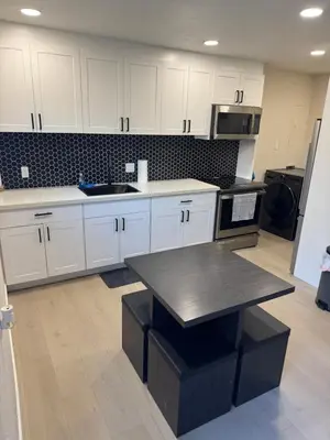 a kitchen with white cabinets and a black table at 2 bed 1 bath special woodlake duplex A in Sacramento