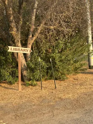 a sign that says library in front of a tree at Home away from Home - 6 miles from the SNP in Three Rivers