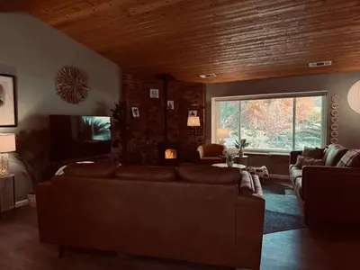 a living room with a couch and a large window at Magic Sequoia Spacious Home in Three Rivers